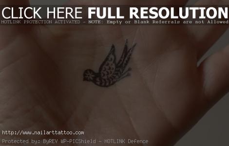 Tiny tattoo of a paisley bird in the palm of the hand. Small tattoos