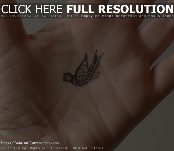 A tiny tattoo of a paisley bird in the palm of the hand. 594x516