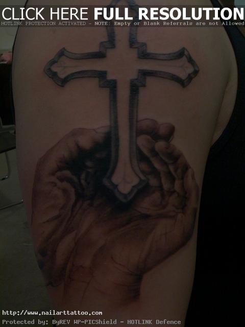 hands with cross tattoo on shoulder