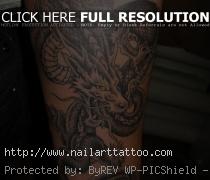 Dark coiled dragon tattoo on forearm