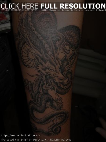 Dark coiled dragon tattoo on forearm 211